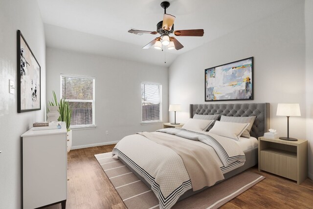 bedroom featuring ceiling fan, dark hardwood / wood-style flooring, and lofted ceiling