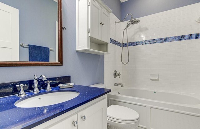 full bathroom with vanity, toilet, and tiled shower / bath combo