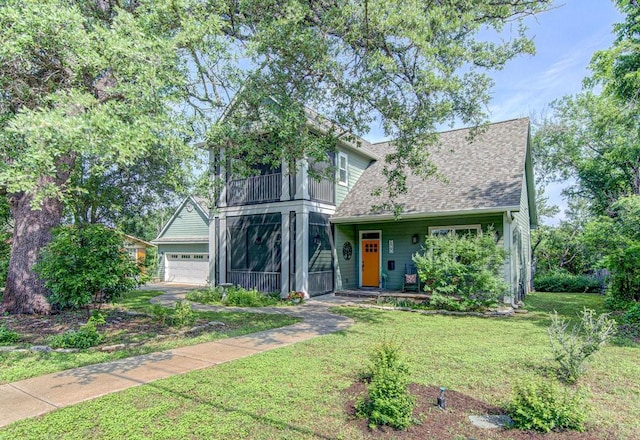 view of front of house featuring a sunroom, a front lawn, and a garage