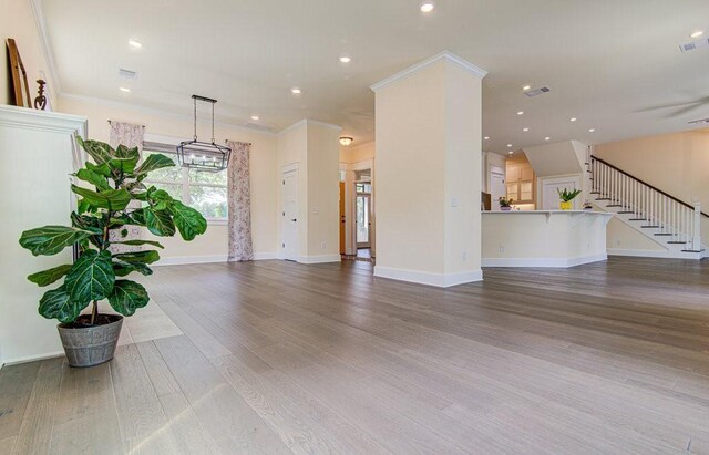 unfurnished living room featuring hardwood / wood-style floors and ornamental molding