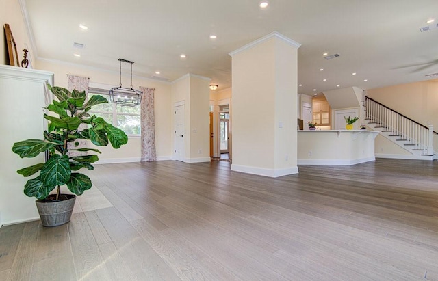 unfurnished living room with hardwood / wood-style floors and crown molding