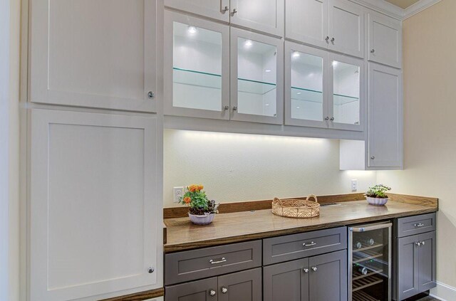 bar featuring gray cabinets, wine cooler, butcher block counters, and crown molding