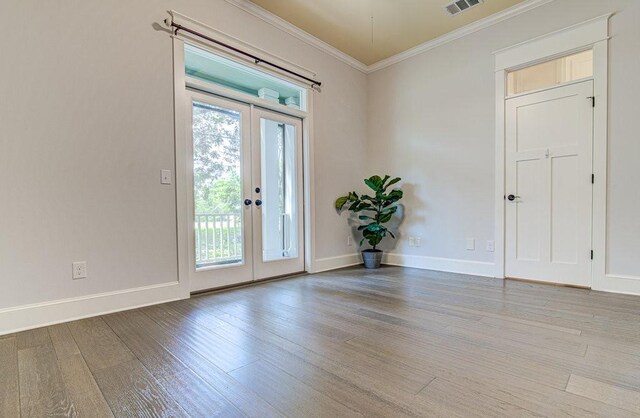 interior space with a wealth of natural light, french doors, crown molding, and light hardwood / wood-style flooring