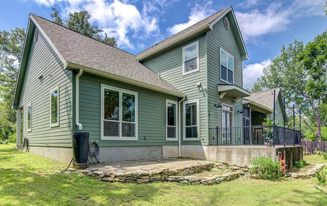 back of house featuring a lawn and a patio