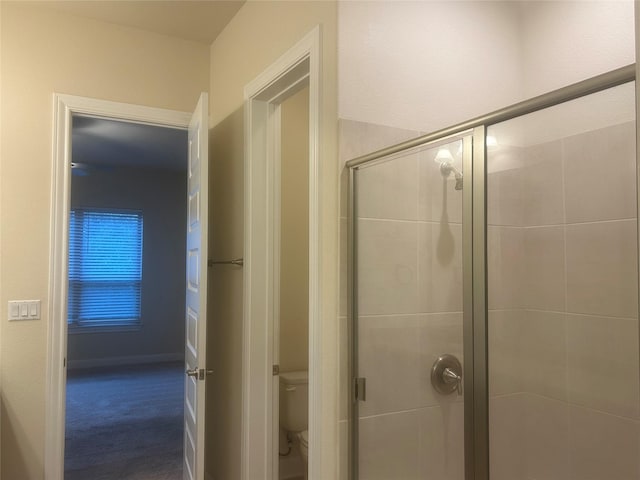 bathroom with toilet and a shower with door