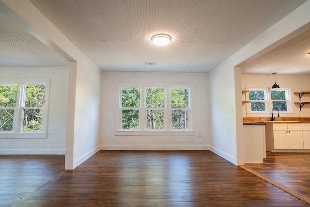 interior space with dark hardwood / wood-style floors, ornamental molding, and sink