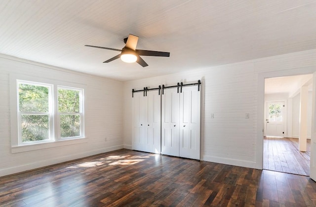 unfurnished bedroom with a closet, ceiling fan, and dark wood-type flooring