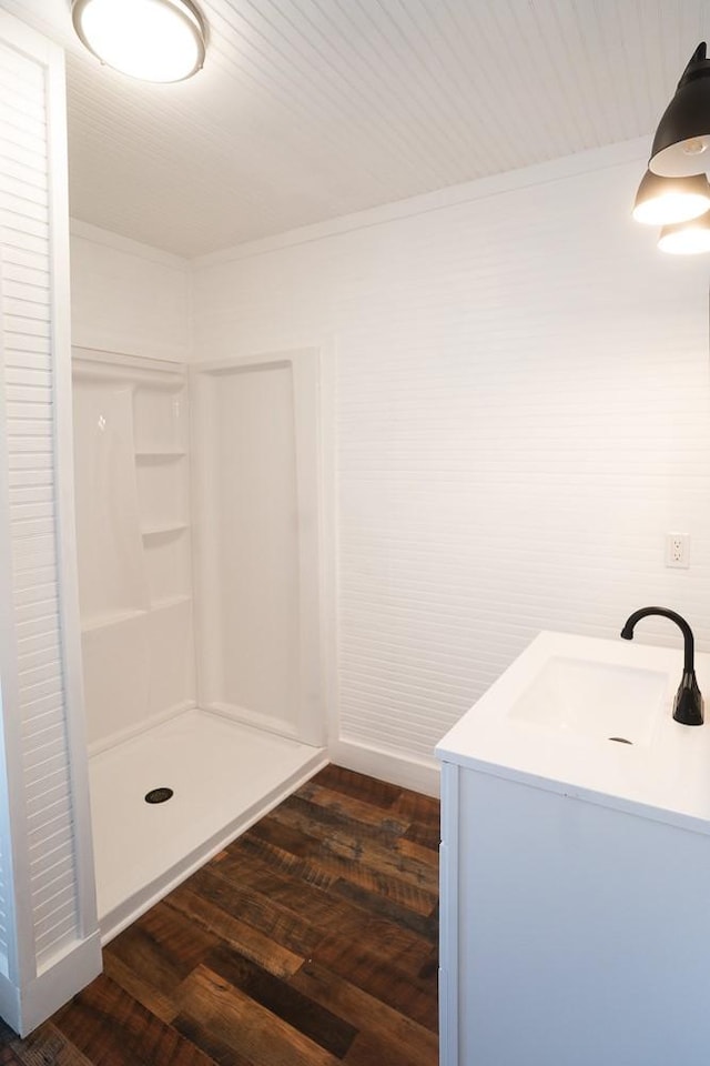 bathroom with a shower, hardwood / wood-style floors, vanity, and crown molding