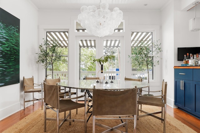 dining space featuring a wealth of natural light, a notable chandelier, and light wood-type flooring