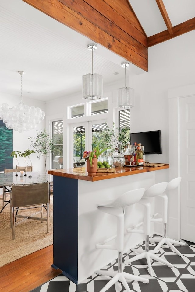 kitchen featuring a kitchen breakfast bar, light wood-type flooring, hanging light fixtures, and an inviting chandelier