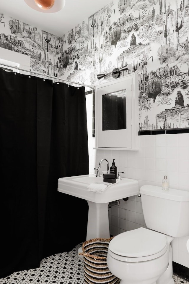 bathroom featuring toilet and tile walls