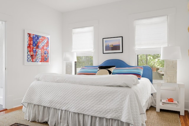 bedroom featuring wood-type flooring and multiple windows