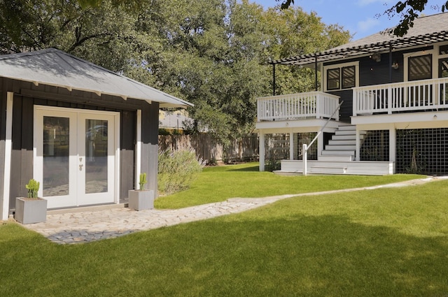 view of yard with a deck and french doors