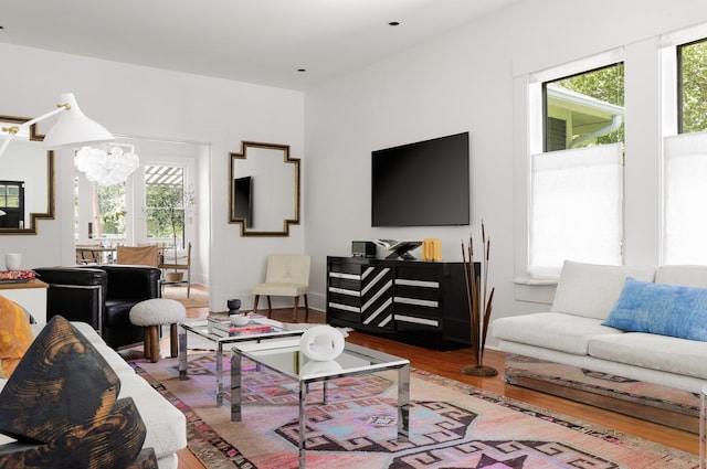 living room featuring hardwood / wood-style flooring and an inviting chandelier