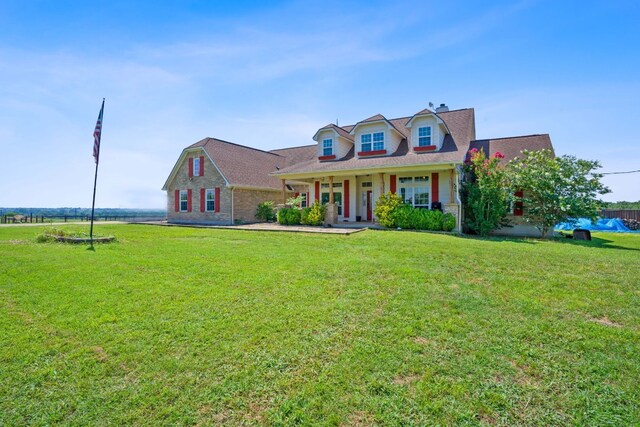 cape cod-style house featuring covered porch and a front lawn