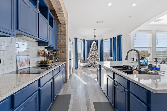 kitchen with black electric stovetop, a sink, and blue cabinetry