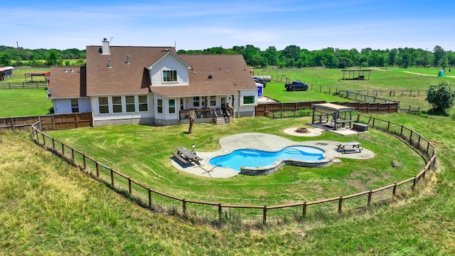 rear view of house featuring a fire pit, a patio, a yard, and a fenced backyard