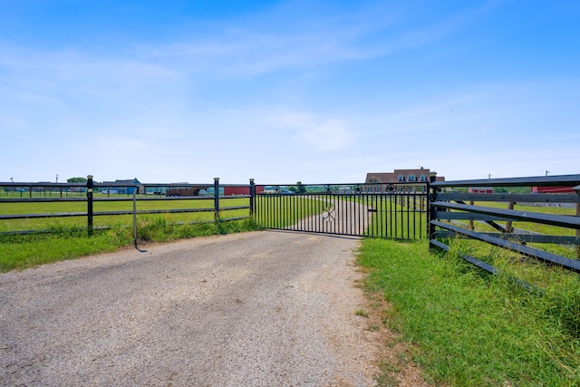 view of gate featuring a rural view and fence