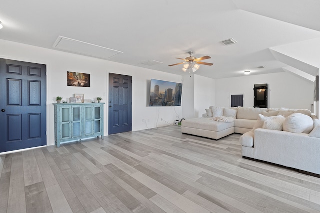 unfurnished living room with light wood-style floors, attic access, visible vents, and ceiling fan