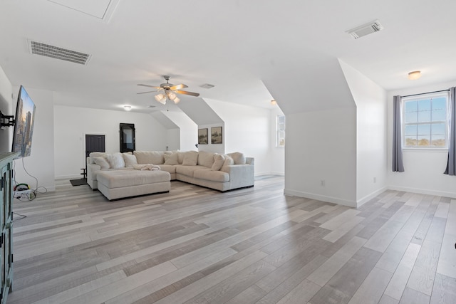 unfurnished living room with light wood-type flooring, visible vents, ceiling fan, and lofted ceiling