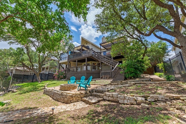 exterior space with fence, an outdoor fire pit, a deck, and stairway