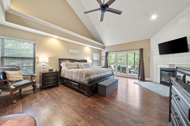 bedroom featuring access to exterior, dark wood-type flooring, high vaulted ceiling, and a large fireplace