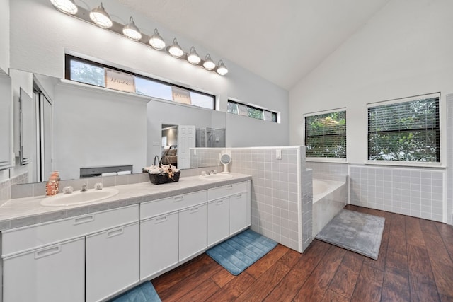 bathroom featuring vanity, a wealth of natural light, a bathtub, and tile walls