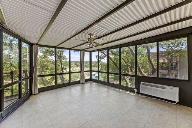 unfurnished sunroom with ceiling fan and a wall mounted AC