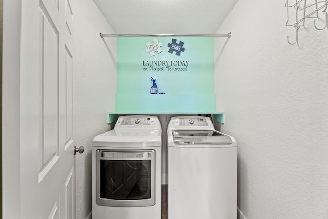 laundry room featuring a textured wall, laundry area, and washer and dryer