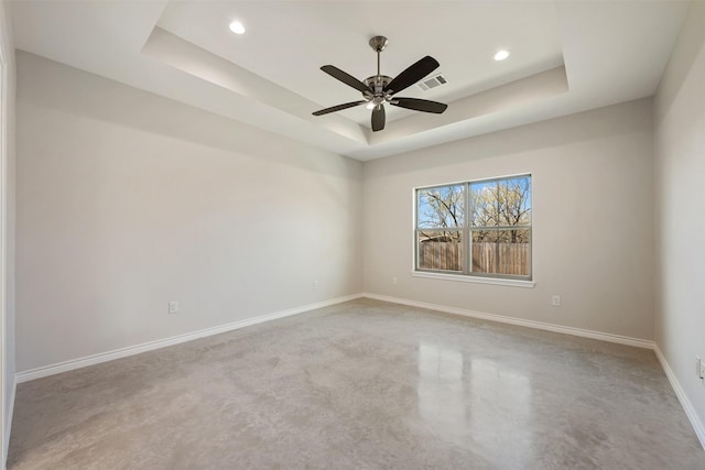 empty room with a tray ceiling and ceiling fan