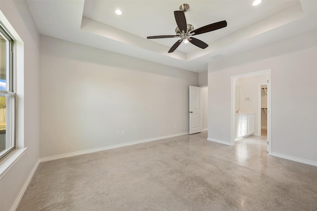 empty room with a tray ceiling and ceiling fan