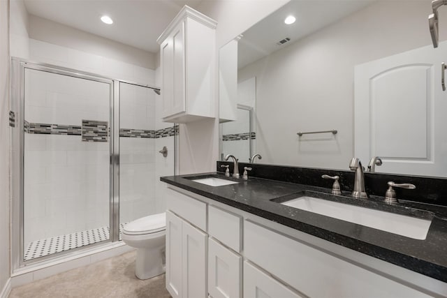 bathroom featuring tile patterned floors, vanity, a shower with shower door, and toilet