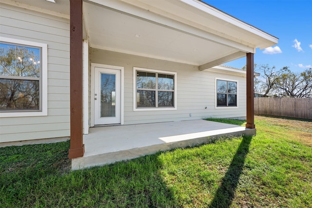 rear view of property featuring a patio and a lawn