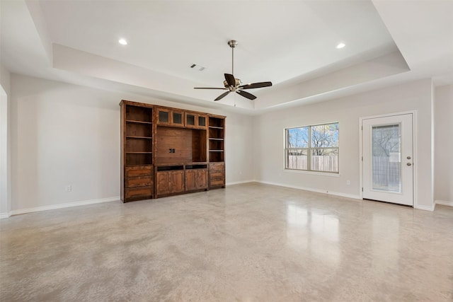 unfurnished living room featuring a tray ceiling and ceiling fan