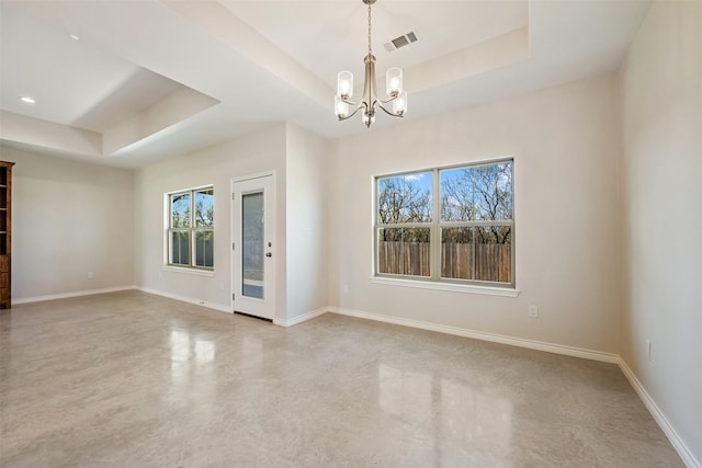 unfurnished room with a chandelier and a tray ceiling