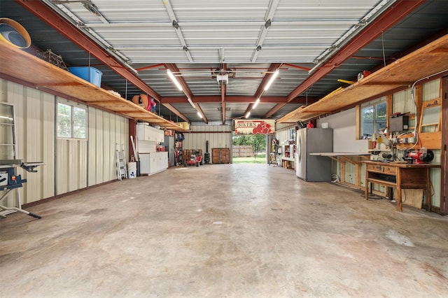 garage with a workshop area and stainless steel refrigerator