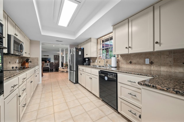 kitchen featuring light tile patterned floors, sink, dark stone countertops, and black appliances