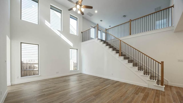 interior space featuring visible vents, a healthy amount of sunlight, wood finished floors, and a ceiling fan