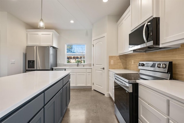 kitchen with stainless steel appliances, hanging light fixtures, white cabinets, and backsplash