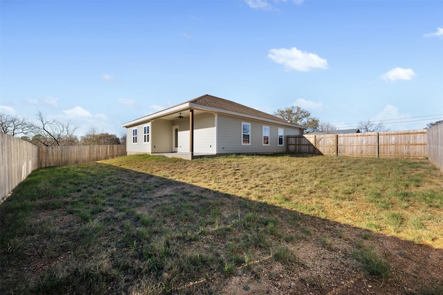 rear view of house with a yard, a patio, and ceiling fan