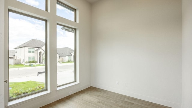 unfurnished room featuring light wood-style flooring and baseboards