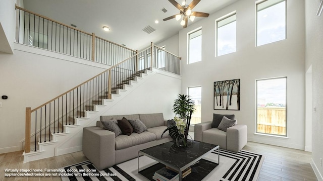 102 Iva Ln, Georgetown, TX 78628 - living area featuring a high ceiling, wood finished floors, stairs, a ceiling fan, and baseboards