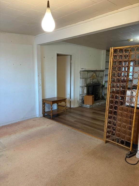 basement with carpet floors and a stone fireplace