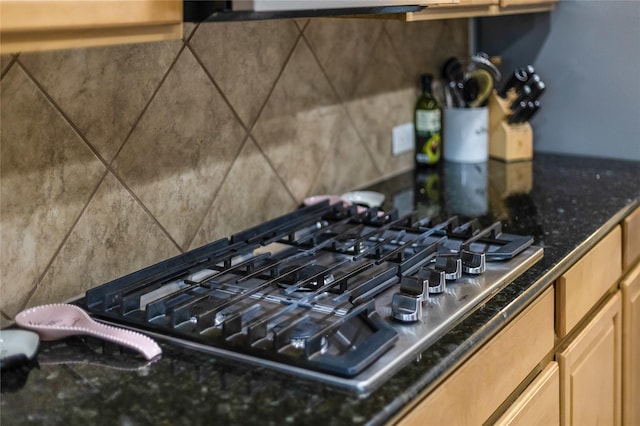 interior details featuring stainless steel gas cooktop and dark stone countertops