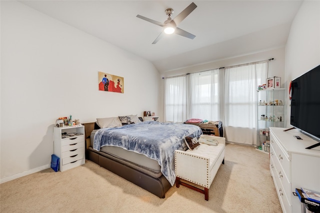 bedroom with ceiling fan, vaulted ceiling, and light carpet