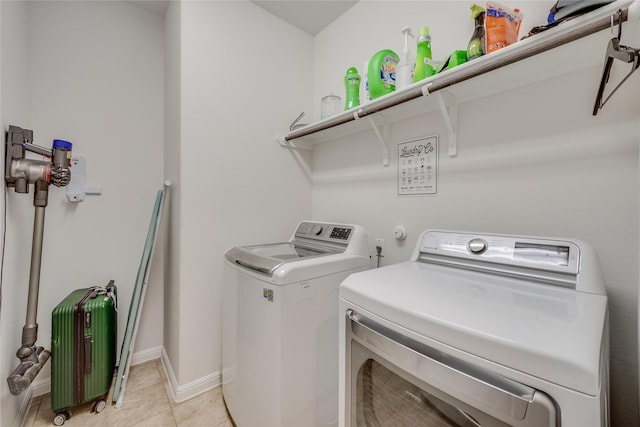 clothes washing area with light tile patterned floors and washing machine and dryer