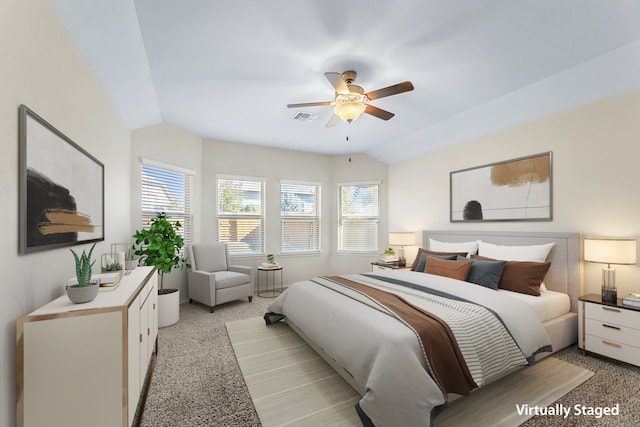 bedroom featuring multiple windows, light carpet, vaulted ceiling, and ceiling fan