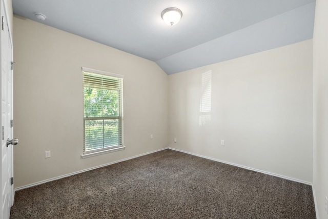 carpeted spare room featuring lofted ceiling