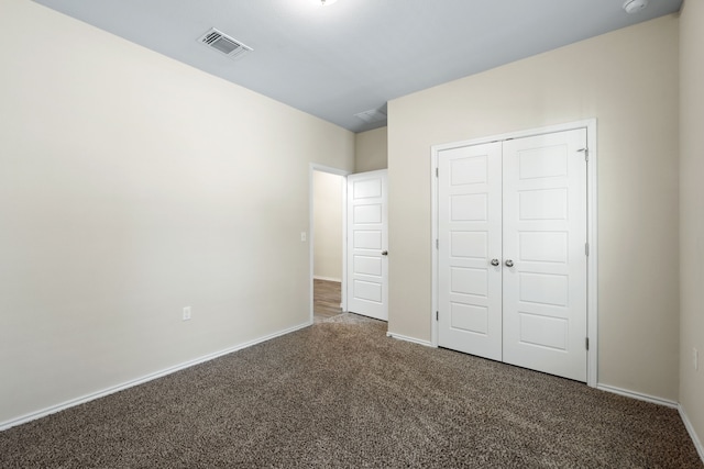 unfurnished bedroom featuring a closet and dark colored carpet