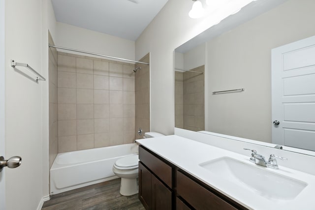 full bathroom featuring vanity, wood-type flooring, tiled shower / bath combo, and toilet